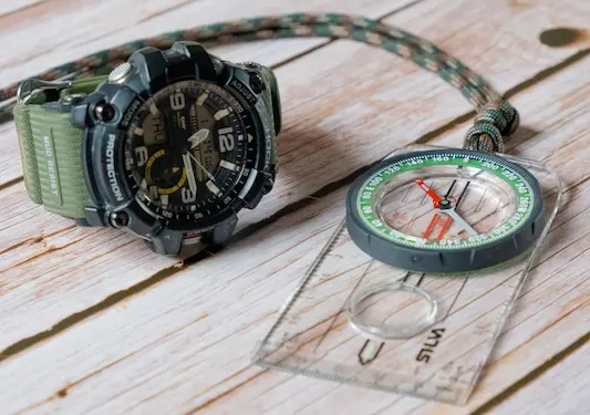 A navigation compass next to an outdoor watch from G-Shock that also includes navigation integration.