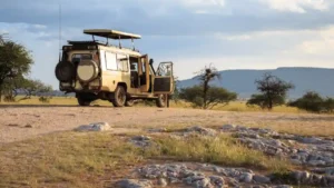 A game drive vehicle with doors open in the African savanna.