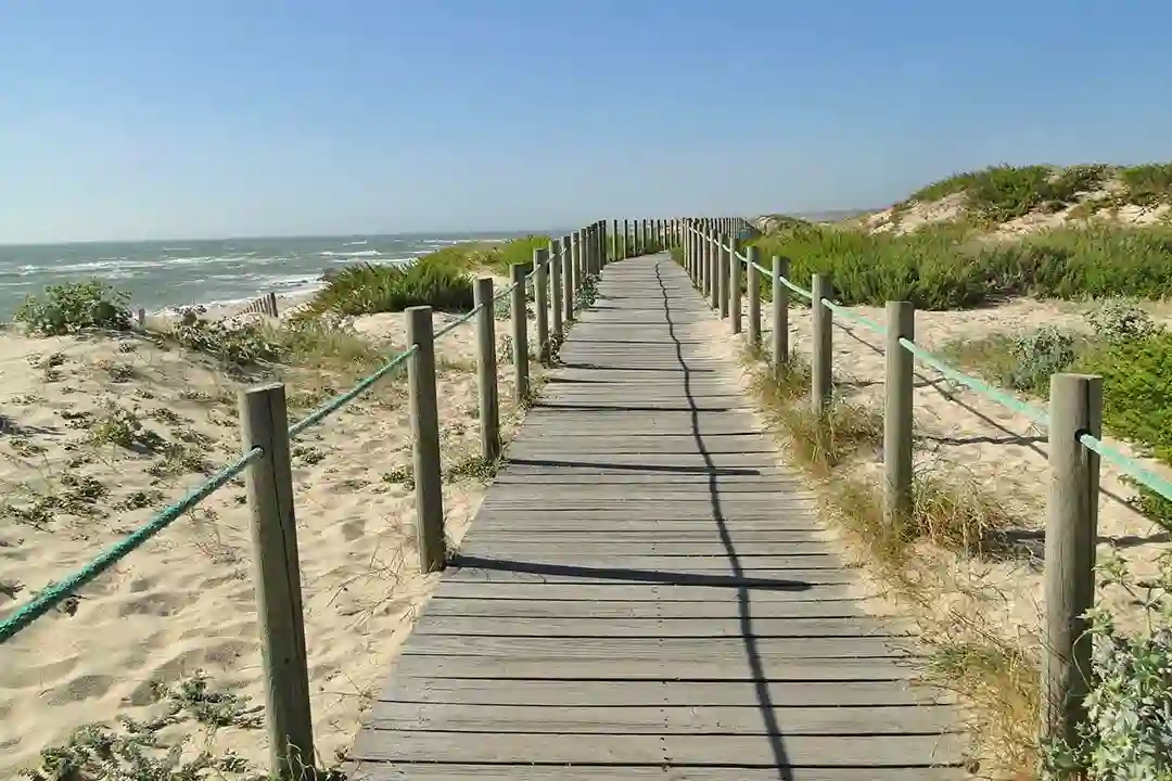 A wooden walkway on a beach next to the Atlantic ocean. 