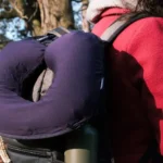 The inflated LayOn Magic Neck Pillow hanging from a backpack.