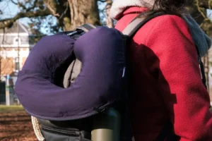 The inflated LayOn Magic Neck Pillow hanging from a backpack.
