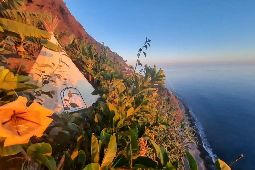 A tent near the edge of a cliff overlooking the ocean at Canto Das Fontes Glamping, one of our favourite glamping stays in Madeira, Portugal.