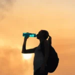 Woman drinking water while on the road and travelling.