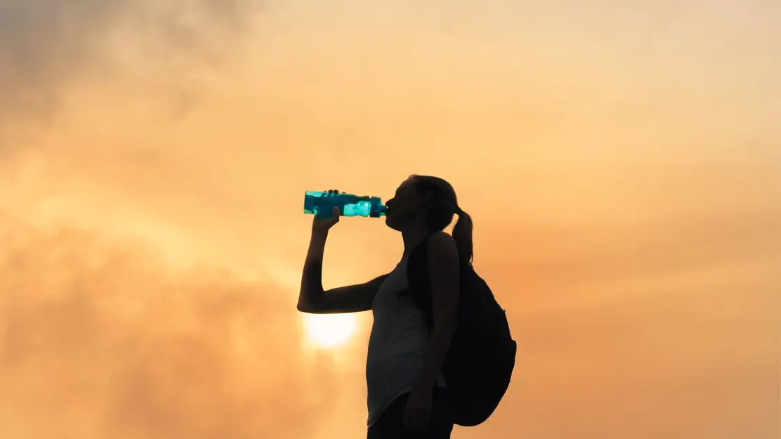 Woman drinking water while on the road and travelling.
