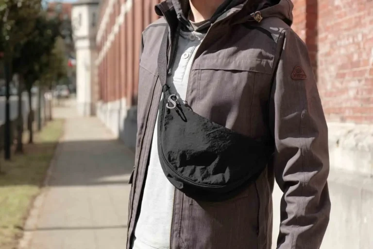 Luca from The Wildest Road wearing a black Uniqlo mini shoulder bag with a carabineer attached to the zipper.