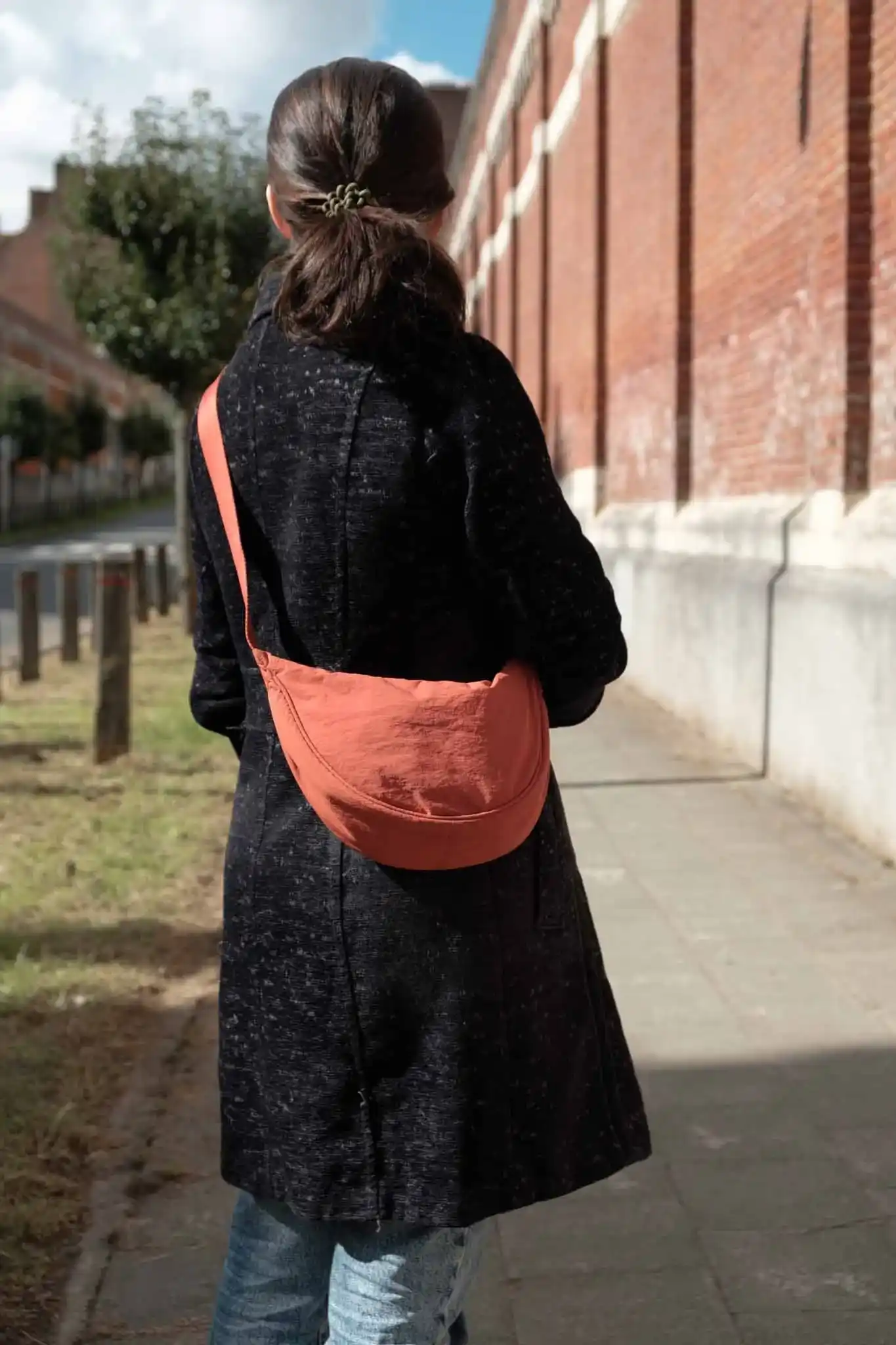 Ana from The Wildest Road wearing an orange Uniqlo mini shoulder bag.
