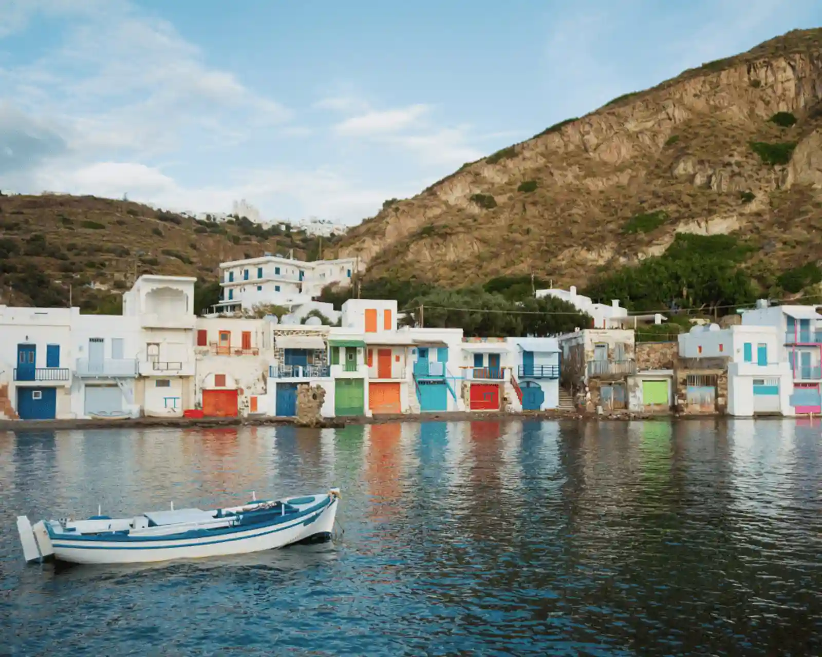 Colourful houses and port in the authentic island of Milos in Greece.