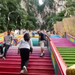 Visitors climbing the colourful stairs leading to the Batu caves in Malaysia.