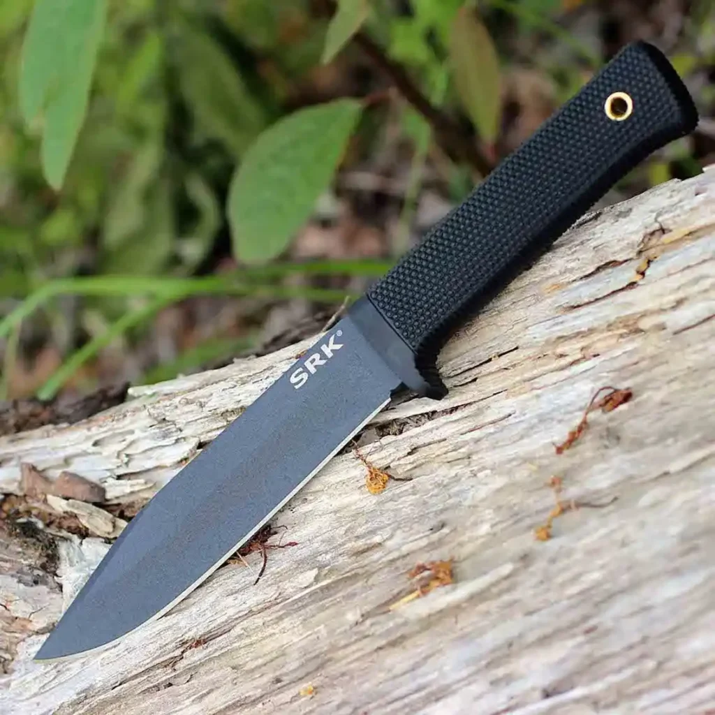 A Cold Steel SRK outdoor knife placed on a block of wood.