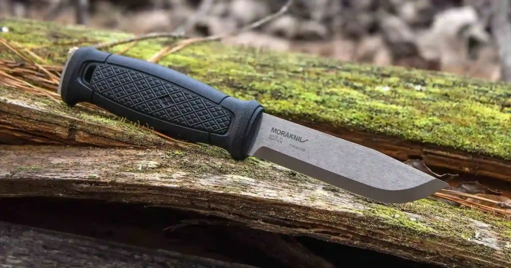 A Morakniv Garber outdoor knife on a fallen tree.