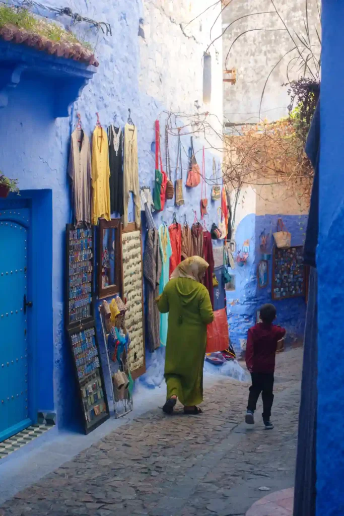 Locals roaming the blue streets of Chefchaouen in Morocco.